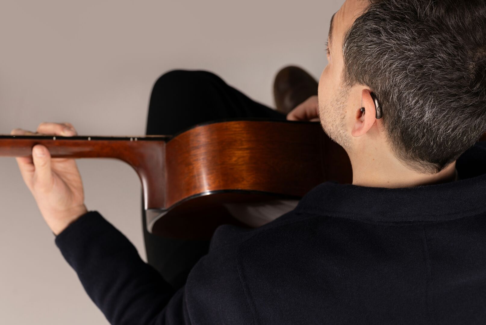 Osoba niedosłysząca z aparatem słuchowym gra na instrumencie